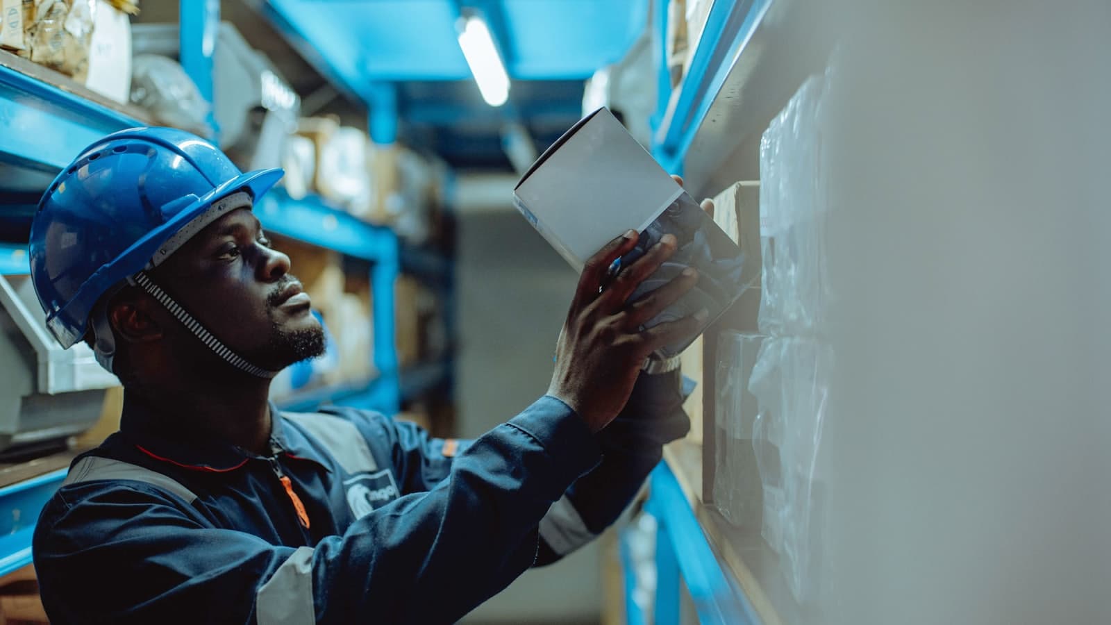 Worker in a hard hat checking stock with a tablet
